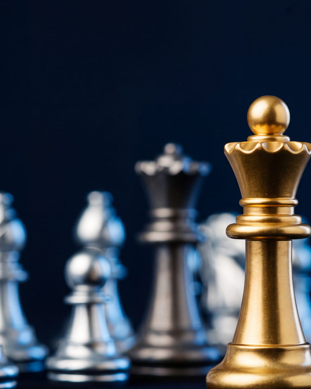 A gold queen standing in sharp focus among the silver ranks, suggesting secured leadership and continuity